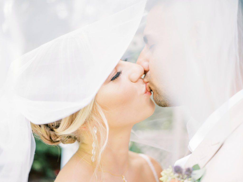 Under the veil kiss for bride and groom