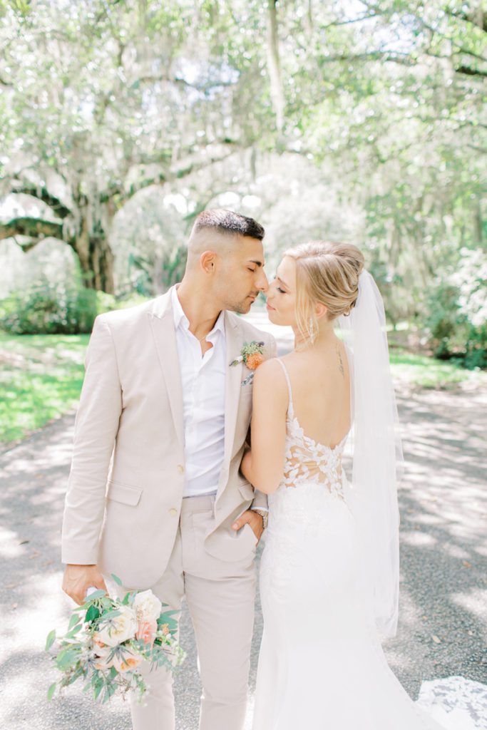 Bride and Groom under oak trees with spanish moss in Charleston Lowcountry