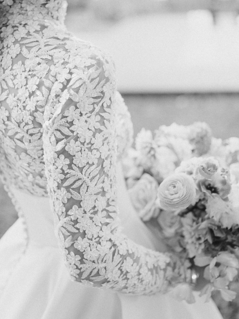 Close up of floral lace sleeve on bride's dress in black and white