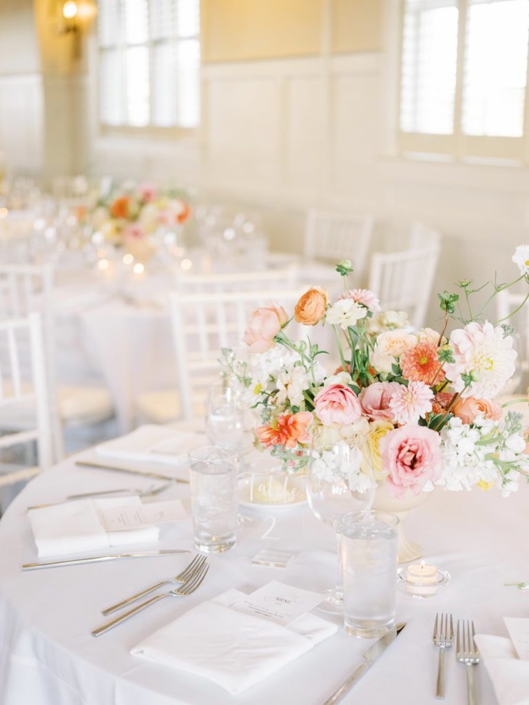White reception hall with colorful blooms as centerpieces 