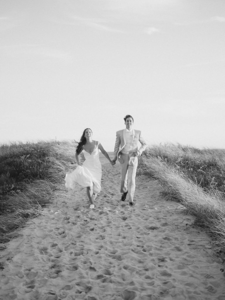 Blurry Bride and Groom running at the beach in black and white