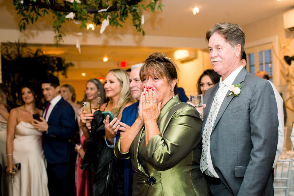 Mother of the Groom smiling with tears in her eyes as her son dances his first dance with his new wife.