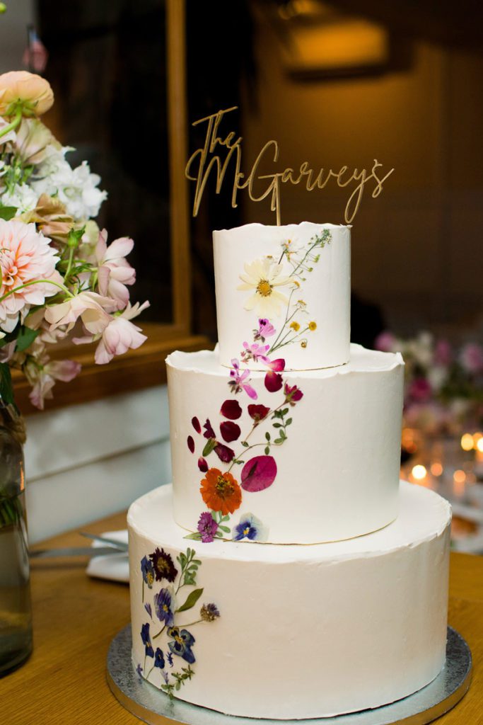 Colorful pressed flower three tier wedding cake