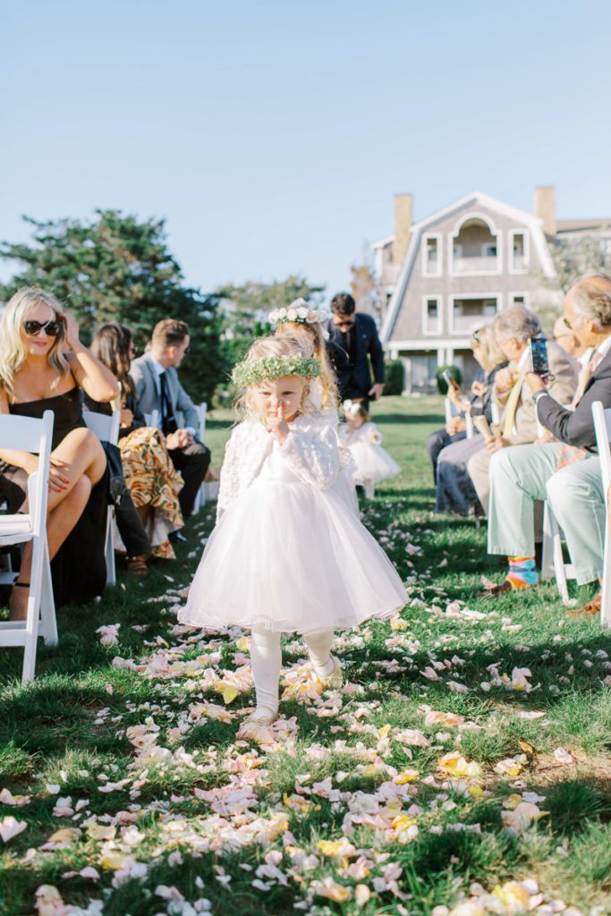 young bridesmaid picking her nose as she walks up the aisle during ceremony processional