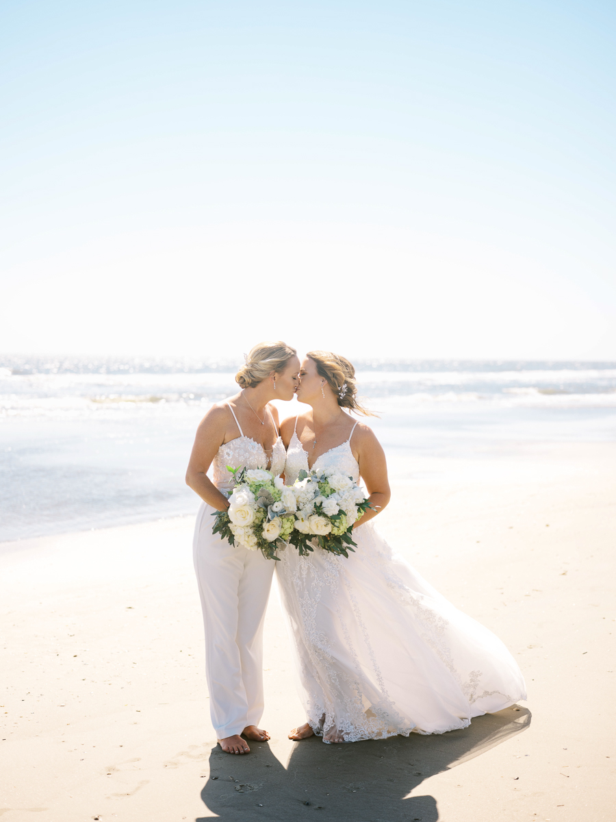 brides kissing on beach