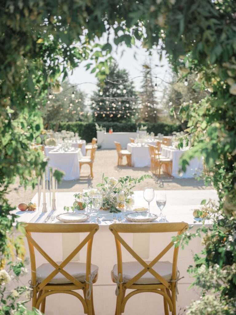 Allegretto Vineyard Resort | wedding reception sweetheart table under floral arch with string lights