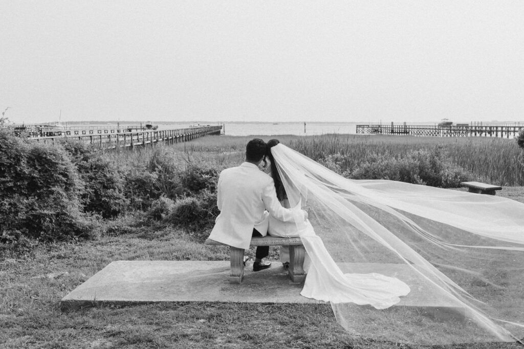 Bride and groom in front of marsh with veil